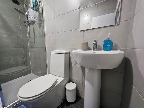 A modern bathroom with a toilet, sink, and shower.