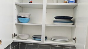 A kitchen with white cabinets, grey and blue dishes, and a built-in oven. - Modern Spacious Flat 10 Minutes from Big Ben (London)
