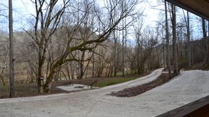 A gravel path leading through a wooded area with benches and a picnic table. - Cozy & efficient cabin w/ river access. Pet Friendly! (Stanton)