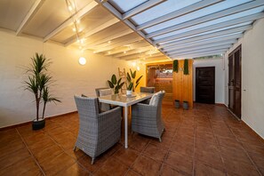 Relax in this inviting living area with a central table, wicker chairs, and a potted plant.