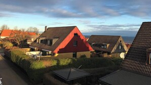 Un quartier résidentiel où les maisons se distinguent par leurs toits pentus et où un imposant bâtiment rouge attire l’attention.