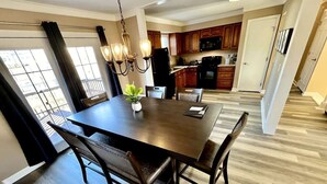 A dining area with a dark wooden table, chairs, and a chandelier. - Spacious 3 Bedroom with Outdoor Pool in Mason (Mason)