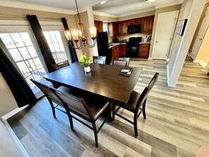 A dining area with a dark wooden table, chairs, and a chandelier. - Spacious 3 Bedroom with Outdoor Pool in Mason (Mason)