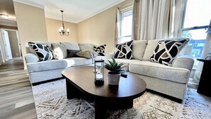 A modern living room with a sofa set, a coffee table, and a patterned rug. - Spacious 3 Bedroom with Outdoor Pool in Mason (Mason)