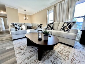 A modern living room with a sofa set, a coffee table, and a patterned rug. - Spacious 3 Bedroom with Outdoor Pool in Mason (Mason)
