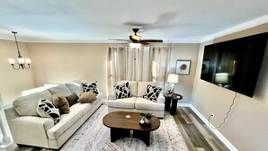 A living room with a sofa, coffee table, and curtains. - Spacious 3 Bedroom with Outdoor Pool in Mason (Mason)