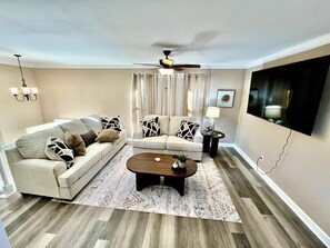 A living room with a sofa, coffee table, and curtains. - Spacious 3 Bedroom with Outdoor Pool in Mason (Mason)