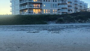 Ein mehrstöckiges Hotel mit Balkonen und Blick auf den Strand.