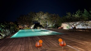 A wooden deck with a pool, two glasses of red drink, and a bowl of fruit. - VILLA Sea View with beautiful swimming pool and enclosed garden, seaside SOUTH CORSICA   (Pianottoli-Caldarello)