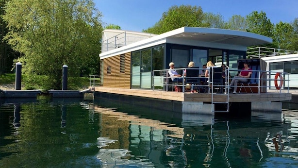 Un bateau moderne doté d’un espace repas couvert et d’une structure vitrée.
