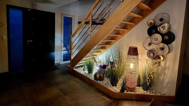 A modern interior with a wooden staircase, a wall-mounted decorative item, and a small indoor garden. - Just 15 minutes from the 24 Hours of Le Mans racetrack! Ideal for 10 people (Pruillé-le-Chétif)
