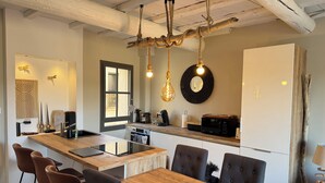 Una cocina moderna con una isla de madera, taburetes de bar y una mesa de comedor.