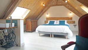 A bedroom with a sloped ceiling, a wooden headboard, a bed with white and blue bedding, a wooden dresser, and a small window. - Detached house in the countryside adapted for disabled people Pets welcome (Osmoy-Saint-Valery)