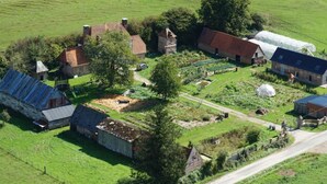 An aerial view of a rural property with multiple buildings, including a large barn, smaller houses, and a greenhouse. - Detached house in the countryside adapted for disabled people Pets welcome (Osmoy-Saint-Valery)