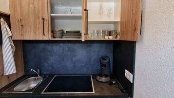 Een koelkast, een oven, een kookplaat, een koffiezetapparaat/waterkoker