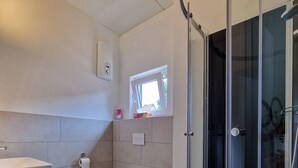 Een badkamer met toilet, wastafel en douche.