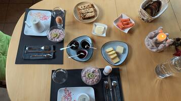 A dining table set with various food items, utensils, and a candle.