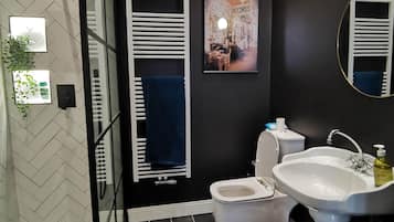 Een haardroger, handdoeken, zeep, toiletpapier