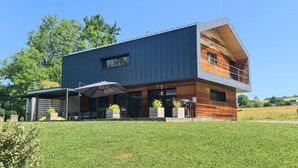 A modern two-story house with a flat roof, large windows, and a covered patio area. - ATYPICAL HOUSE with swimming pool and spa in the countryside 15 minutes from Annecy (Annecy)