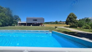 A swimming pool with a house in the background. - ATYPICAL HOUSE with swimming pool and spa in the countryside 15 minutes from Annecy (Annecy)