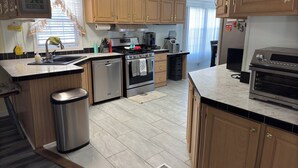 Una cocina moderna con armarios de madera, electrodomésticos de acero inoxidable y un horno empotrado.