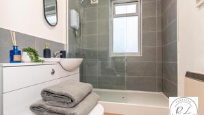 A modern bathroom with a glass-enclosed shower, a white sink, and a toilet. - 1br-2guests-freeparking-wifi-tv (Wigston)