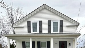 A two-story white house with a front porch, a small garden, and a mailbox. - Medina Square Retreat - Spacious 4 bdrm home walking distance to the square (Medina)