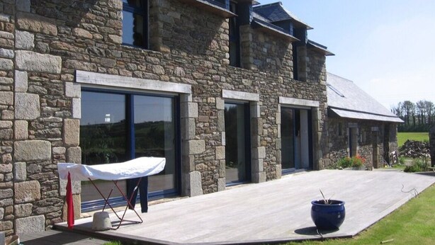 A stone building with large windows and a covered outdoor area. - Spacious, comfortable farmhouse facing the sea (Locmaria-Plouzané)