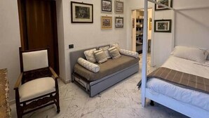 A bedroom with a bed, a sofa, a chair, and a wardrobe. - Corvetto View (Genoa)