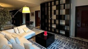 A modern living room with a sofa, a coffee table, a patterned rug, and a checkered wall. - Corvetto View (Genoa)