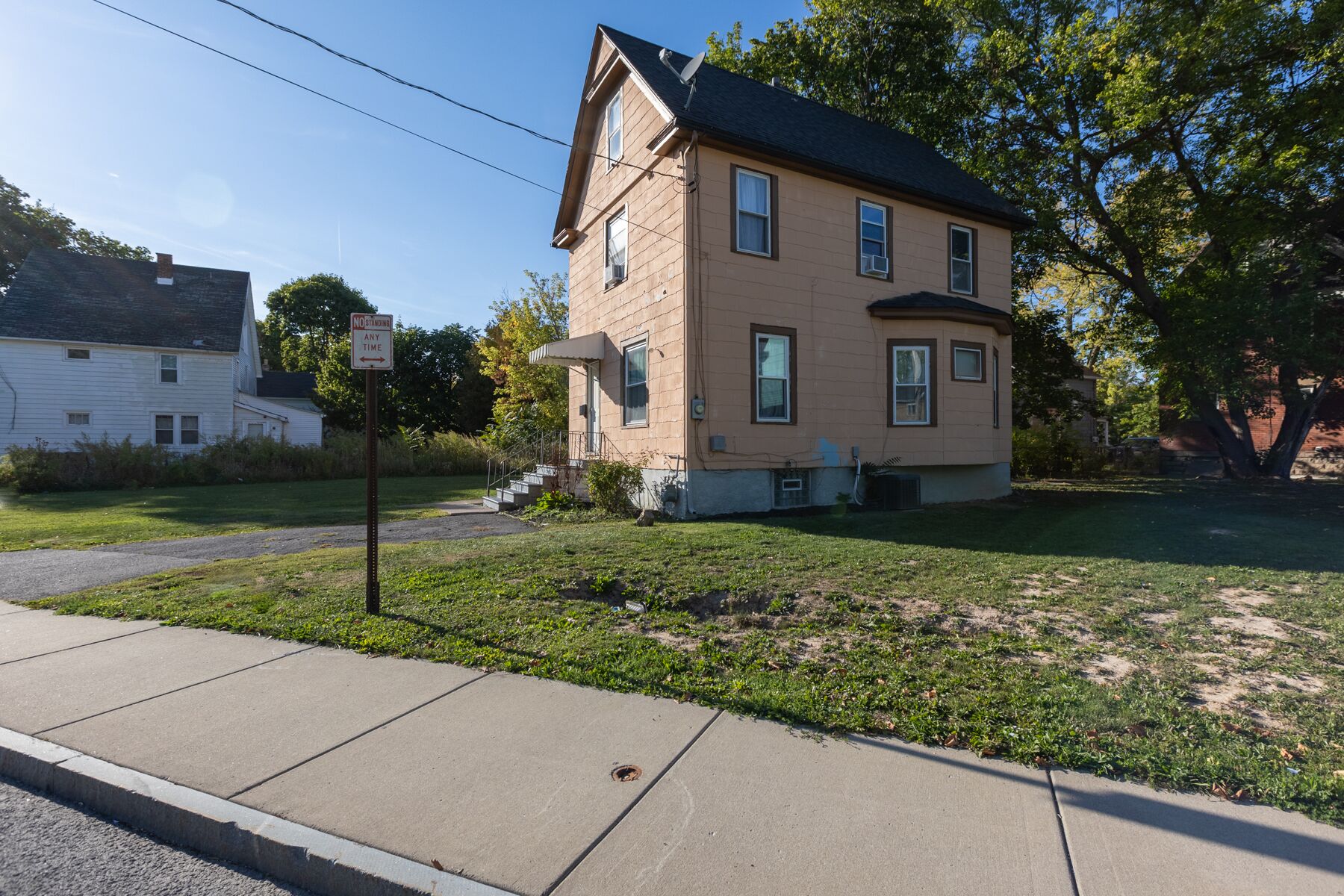 A two-story house with a front porch and a satellite dish.