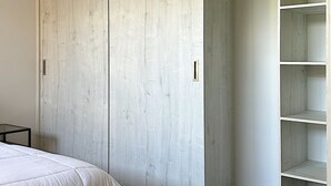 Ein Schlafzimmer mit einem Bett, einem Holzschrank und einem kleinen Tisch.