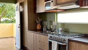 Eine moderne Küche mit Holzausstattung, einem Einbauofen und einer Mikrowelle.