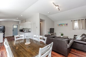 Un espace de vie moderne comprenant un coin repas, une cuisine et un coin salon.