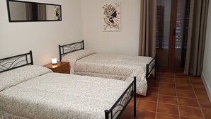 A room with two beds, a nightstand, a wall-mounted mirror, and a door with a view. - HOME TO ENJOY IN STYLE !!!! Garden, barbecue, swimming pool, swings, ping-pong. (Arguedas)
