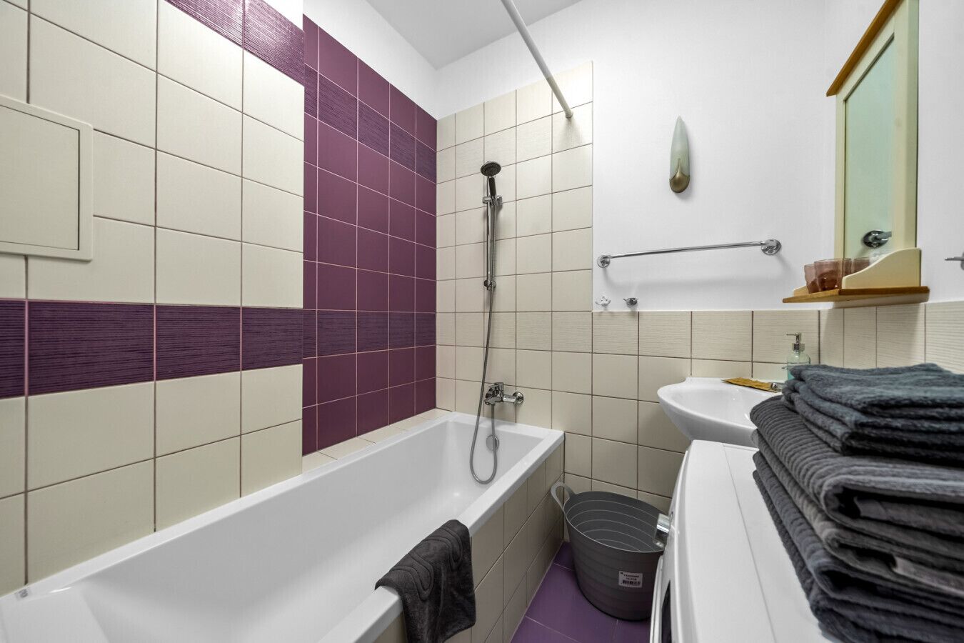 Une salle de bain avec une baignoire, une douche, un lavabo et un miroir.