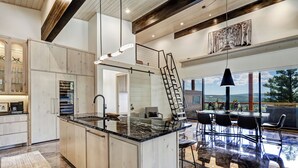A spacious kitchen with a large island, modern appliances, and a dining area with a view. - Breathtaking Views, Indoor/Outdoor Linear Fireplace, Sauna (Angel Fire)