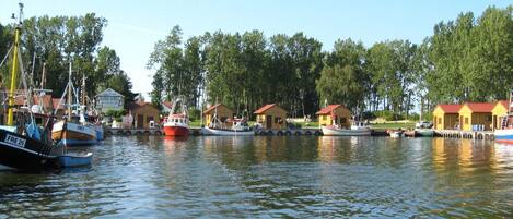 A marina with several boats docked and small cabins along the shore.