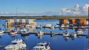 A marina with boats docked, a small building, and a clear sky. - Hausboot in Kroeslin am Bodden (Kröslin)