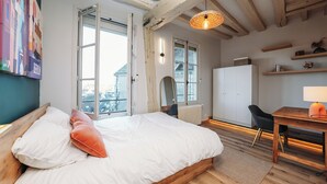 Une chambre à coucher comprenant un lit, un bureau, une chaise et une armoire.