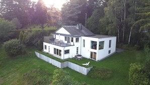 A modern two-story house with a flat roof, large windows, and a balcony. - Panoramic Villa With Private Sauna in Erezee (Erezee)