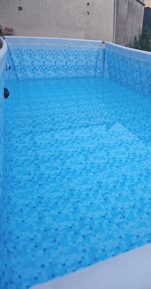 Une piscine rectangulaire dont le fond est recouvert de carreaux.