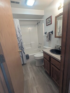 A bathroom with a bathtub, toilet, and sink.