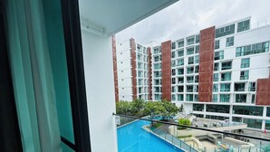 Un balcon donnant sur une piscine et les bâtiments adjacents.