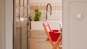 Una cucina con un piano di lavoro bianco, un lavello e un'illustrazione di un pesce incorniciata al muro.