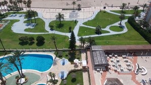 Ein Resort mit großem Pool, Strand und gepflegtem Rasenbereich.