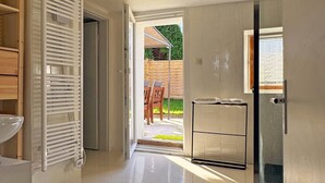 A modern bathroom with a shower, a toilet, and a sink. There is a wooden cabinet and a towel rack. - Cozy Bavarian home with fireplace and fully equipped kitchen. (Moorenweis)