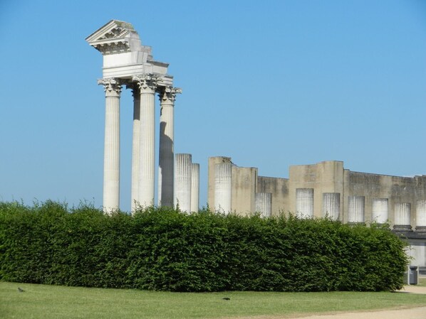 A structure with columns and a flat roof, surrounded by a hedge. - Hausboot am Xantener Nordsee (Xanten)