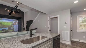 Eine moderne Küche mit Granit Arbeitsplatte, Edelstahlspüle und einem integrierten Geschirrspüler.