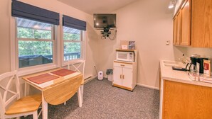 A compact kitchen with a dining area, a microwave, and a television. - DePerrys On The Lake Waterfront Access to Lake Superior (Bayfield)